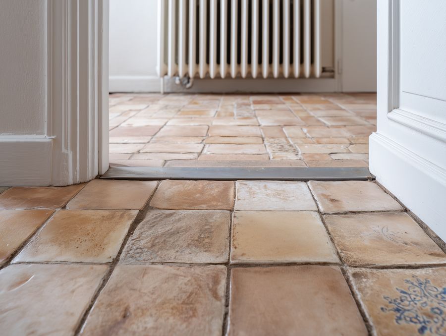 Oude keramische tegelvloer met voegen, situatie voor microcement renovatie